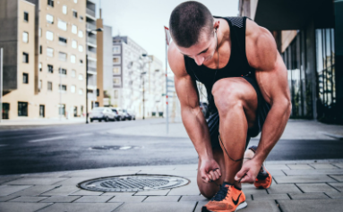 Muscular man tying his shoes