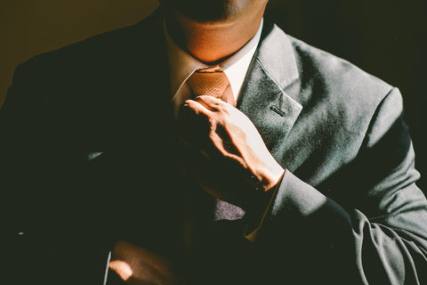 Business man adjusting his tie on a suit