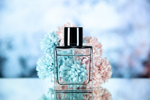 Perfume dupe bottle with blue and pink flowers in background