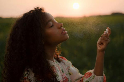 A woman using a pheromone perfume during a sunset