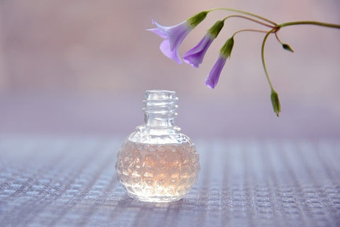 A perfume bottle with flower above
