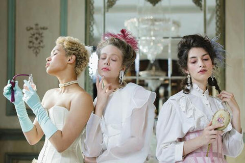 Three women are smelling the perfume scent