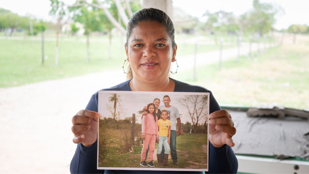 A women holding her family portrait printed by Fede