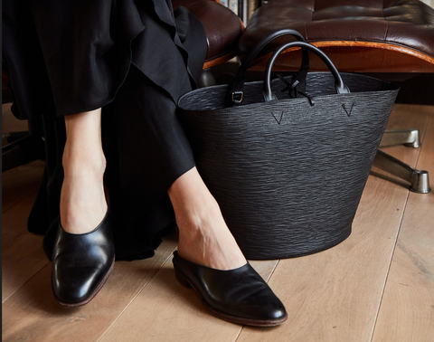 woman wearing black enzo bonafe shoes with large black cesta bag