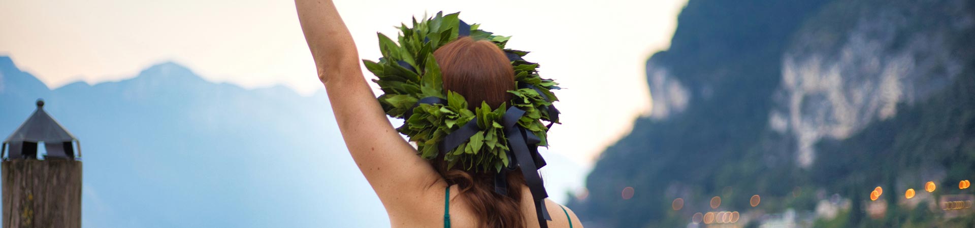 A woman raising her arm with a Bay Laurel wreath on her head