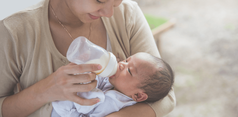 Mother feeding her baby Kendamil baby formula