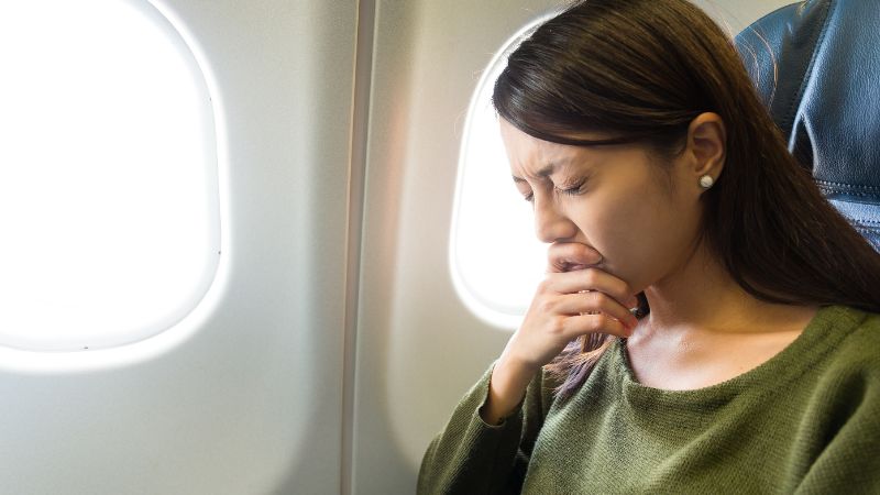 an women feeling sick on an airplane