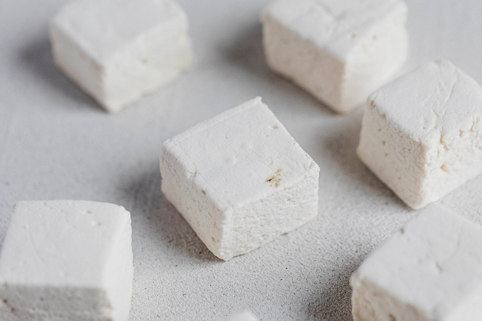 handcrafted vanilla marshmallows on black wood background