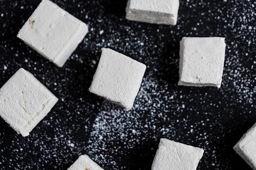 handcrafted vanilla marshmallows on black wood background