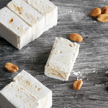 handcrafted marshmallows with peanuts on a wooden board