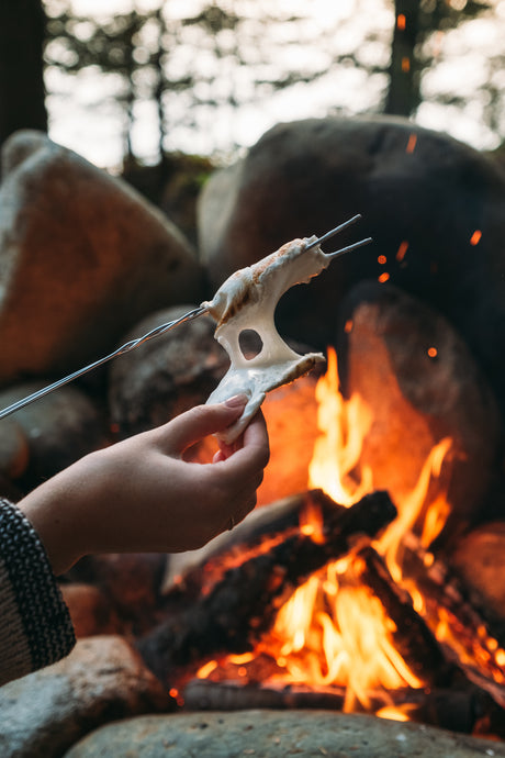 gooey handcrafted marshmallow being pulled apart by campfire