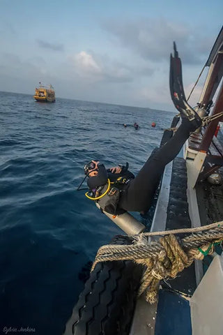 Ein Taucher, der mit der Rückwärtsrolle in das Meerwasser eintaucht, bei Koh TaoThailand