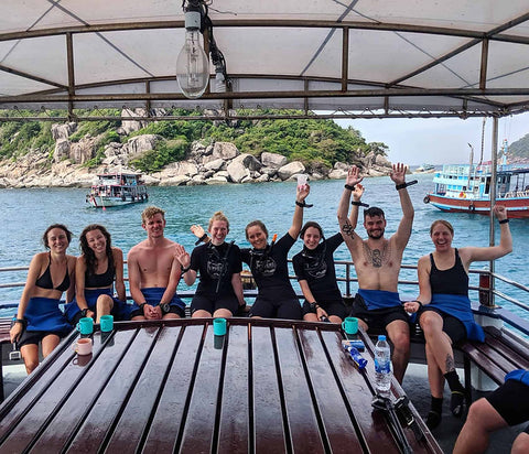 Buceadores felices en el barco Coral Grand Divers