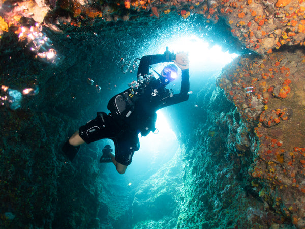 พีดี Divemaster ในปล่องไฟอันโด่งดังว่ายในแนวดิ่ง Sail Rock, เกาะเต่า ประเทศไทย