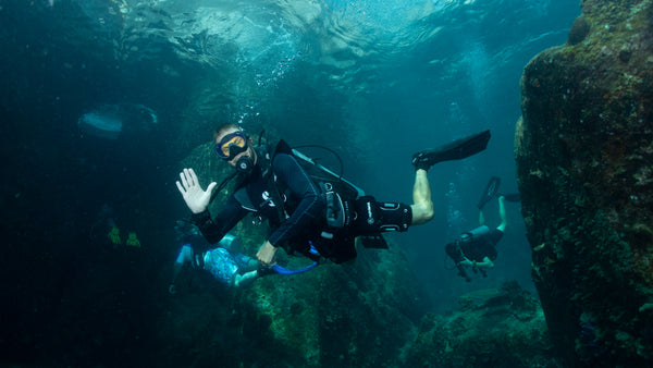 subacquei nelle acque limpide del sito di immersione di Laem Thien a Koh Tao