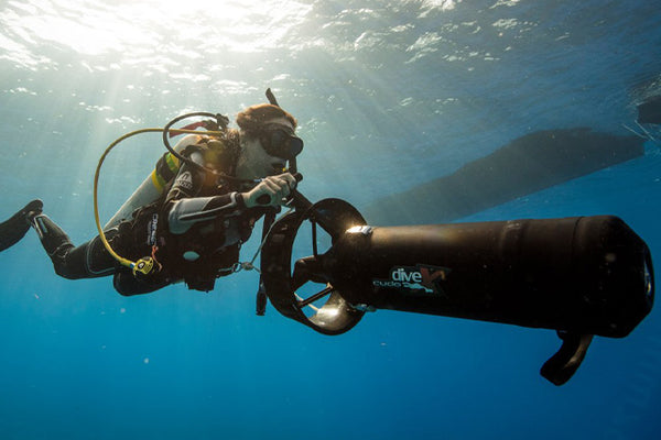 plongeur utilisant un véhicule de propulsion de plongée sous l'eau