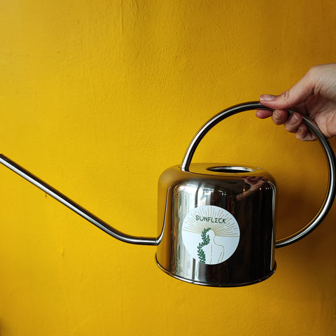 watering can sunfleck logo hand yellow wall