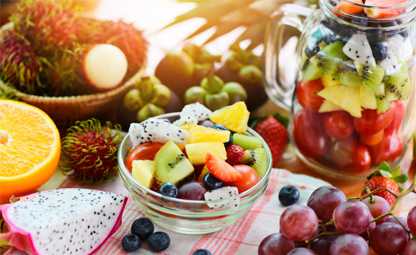 Sliced exotic and healthy fruits in a glass bowl and mug