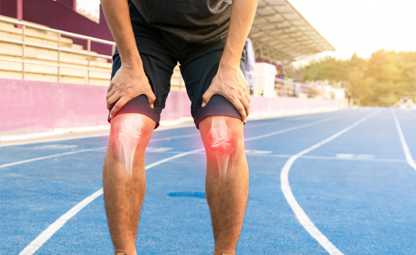 A person holding his knees in joint pain