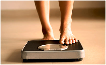 A person checking their weight in a weighing machine