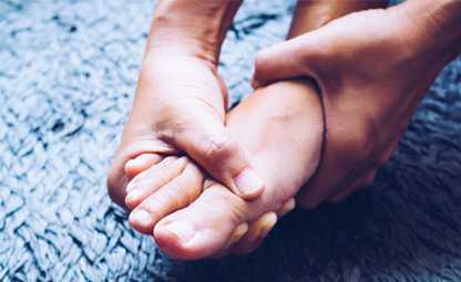 Person holding their foot due to gout pain