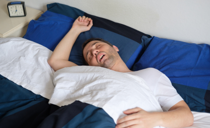 A man sleeping sideways with his mouth open