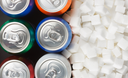 Sugar next to soda or energy drink cans