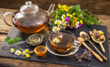 Ayurvedic ingredients, flowers, herbs with herbal tea and a chamomile flower