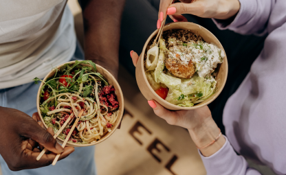 Two people having healthy food bowls with a chopstick and a spoon