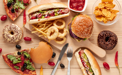Unhealthy junk food- Onion rings, fries, burgers, nachos, pizza, hotdogs and doughnuts