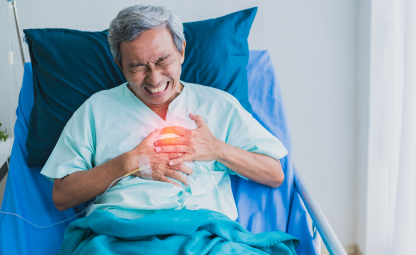 An elderly having chest pain while sitting on a hospital bed due to a heart attack