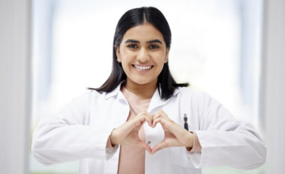 A doctor making a heart health sign with her hands