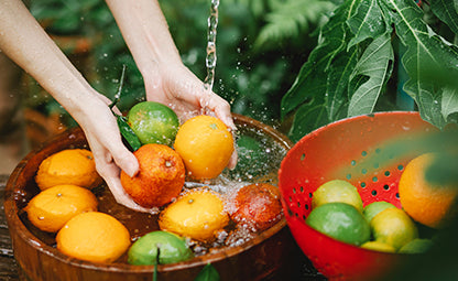 Washing fruits and oranges with hand in a wooden