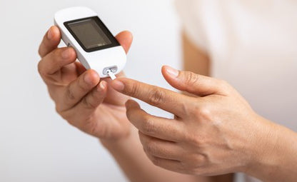 A person checking blood glucose levels with a glucometer