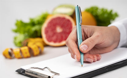 Person writing with a pen on a paper. Measuring tape and fruits in the background