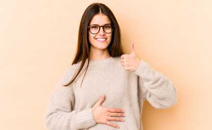 A woman with good gut health doing a thumbs-up