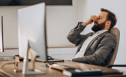 A tensed man under stress and pressure while working on a computer