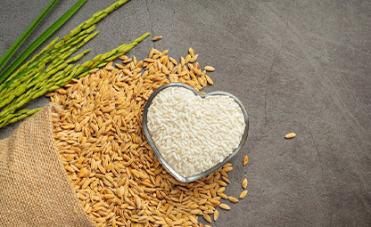 Raw rice and rice grain in heart heart-shaped bowl
