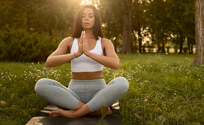 A woman doing Suryanamaskar yoga pose in the park