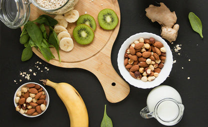 Healthy foods, fruits and nuts- sliced avocados, nuts, ginger, and bananas