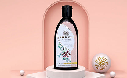 Preserva Wellness Tressgrow Oil on a white podium with a pink background