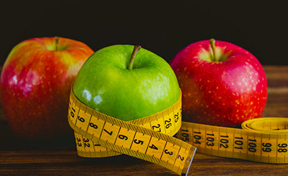 Red and green apples with a measuring tape