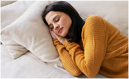 A woman sleeping on the couch with pillows