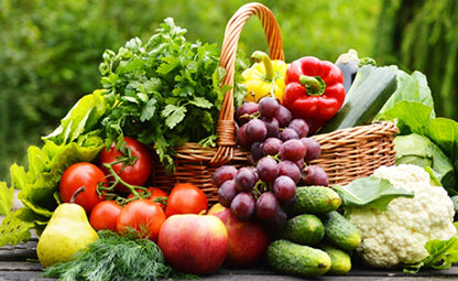 A wooden basket filled with fresh organic vegetables and fruits