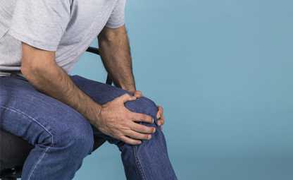A person holding their knee due to arthritis joint pain