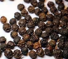 Dried black pepper on a wooden table