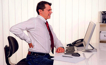 A man having back pain while sitting in the office chair