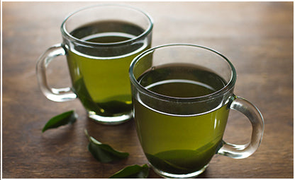two cups of green tea on a wooden table