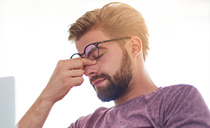 A man having eye stress and pain while holding the eyes