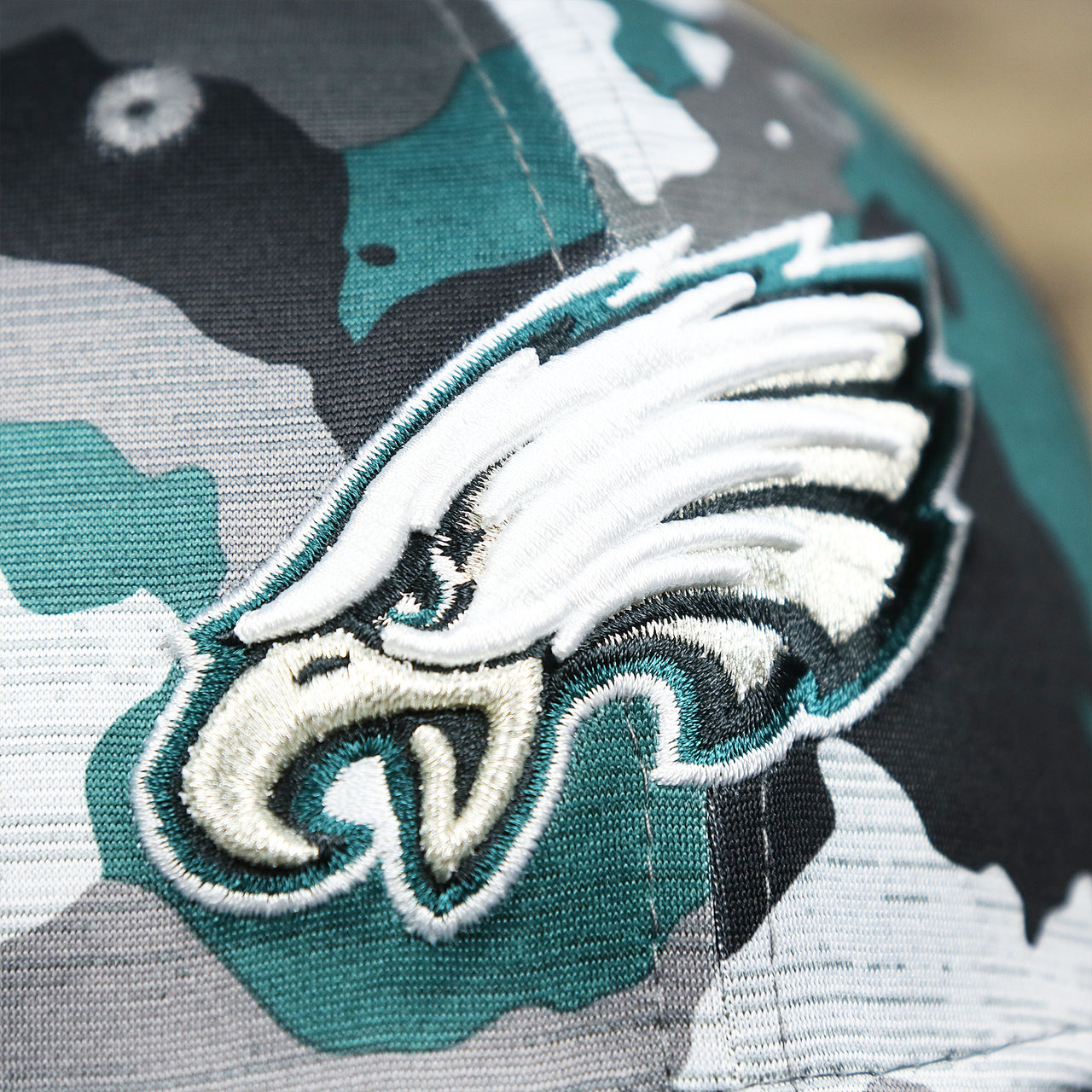 The Eagles Logo on the Philadelphia Eagles Summer Training 2022 Camo 39Thirty FlexFit Cap | Midnight Green Camo 39Thirty Cap